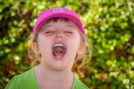 Little girl standing in a park and shouting loudlyの写真素材