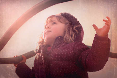 Cute little girl looking up while playing outsideの写真素材