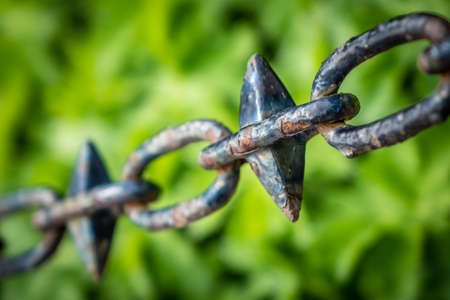 Close up of an old rusted chain against green backgroundの写真素材