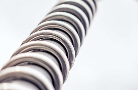 Close up of a twisting metal spiral over white backgroundの写真素材
