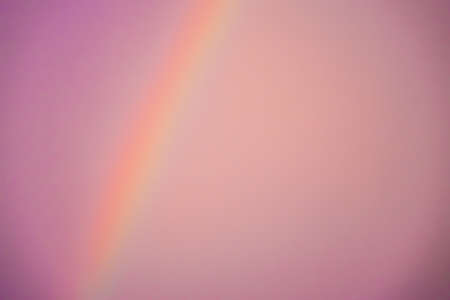 Blurred abstract pinkish background of a rainbow and the skyの写真素材