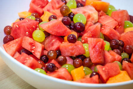 Close up of a large bowl of fresh fruits on a table served for breakfastの写真素材