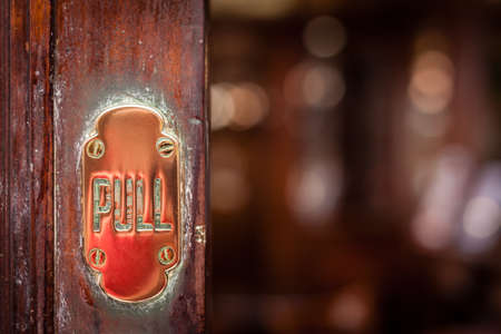 Door detail - pull plaque - at the entrance to the traditional English pub in London, UKの写真素材
