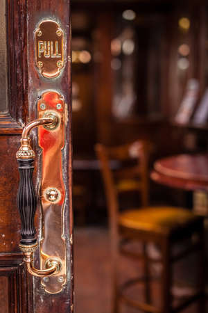 Door handle at the entrance to the traditional English pub in London, UKの写真素材