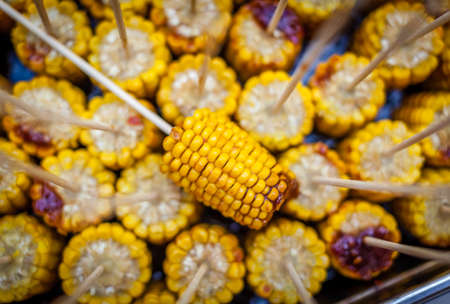 Fresh corn grilled during an outdoors barbecueの写真素材
