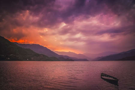 Sunken boat at the lake in Pokhara at sunset, Nepalの写真素材