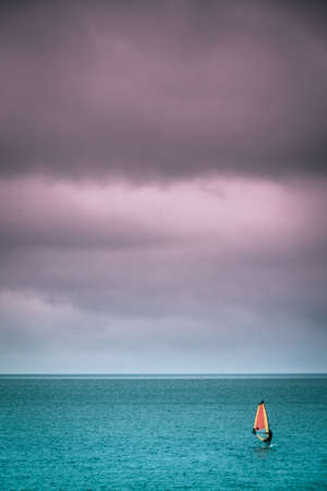 Single man windsurfing on a surface of a sea in Devon, Englandの写真素材