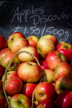 Fresh yellow and green apples for sale stored in retro grunge baskets in the market in a small...
