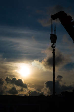 Heavy duty crane with top cable pulley and hook photographed at sunsetの写真素材