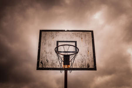 Old disused outdoor basketball hoop on a stormy, cloudy dayの写真素材