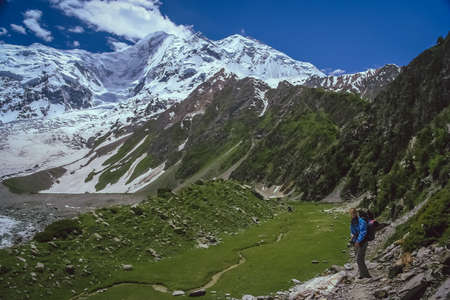 Trekker walking on a trail leading to the base camp of Rakaposhi in Karakorum in Pakistanの写真素材