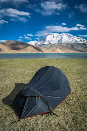 Pitched tent at the stunning Kara Kul lake, Chinaの写真素材