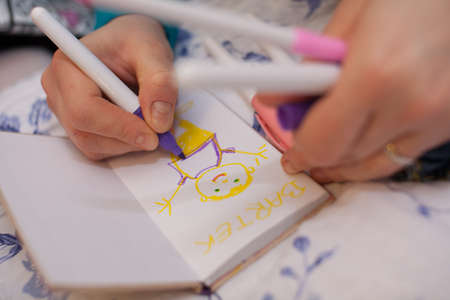 Little girl drawing a picture of her brother Bartek