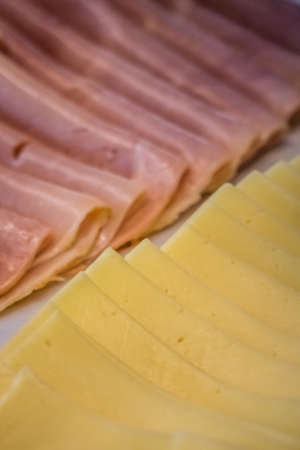 Ham and cheese slices on a plates on a self service breakfast counter in a hotel restaurantの写真素材