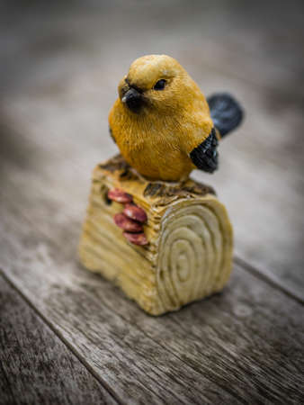 Small birdie figurine standing on a wall in the gardenの写真素材