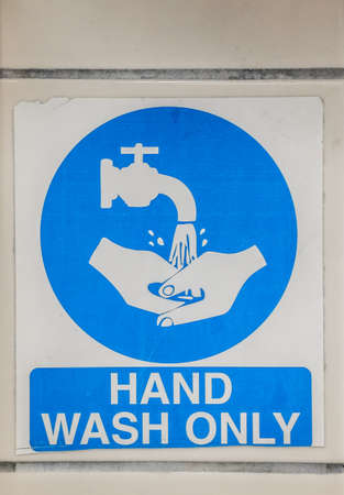 Hand wash only sign on a kitchen wall above sinkの写真素材