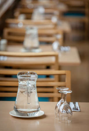 Wine glasses, coffee cups and cutlery on the table before the start of the service in the restaurantの写真素材