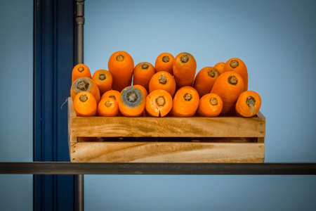 Carrots in a wooden basket on a shelf in a smoothie barの写真素材