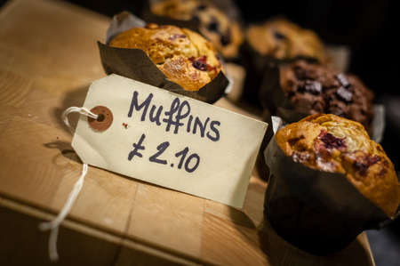 Muffins on display with the price tag indicating how much they costの写真素材