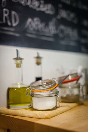 Table with condiments and additives like oil, vinegar, sugar, etc, in a student canteenの写真素材