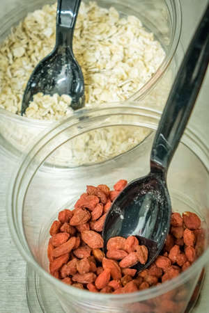 Goji berries and oats in plastic cups used as ingredients of healthy smoothies in a healthy food bar