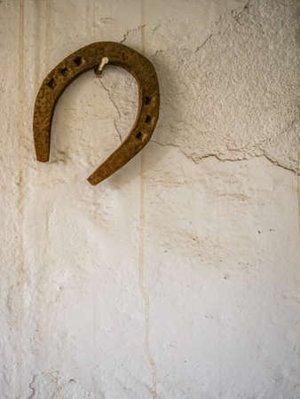 Horseshoe hanging on a wall in a barn in a farmの写真素材