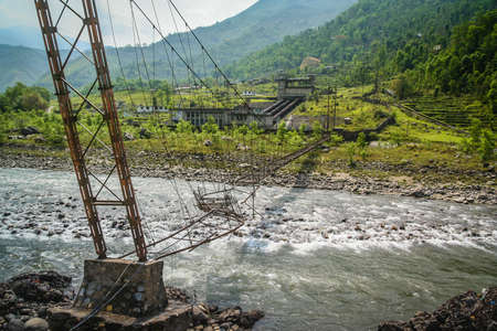 Damaged bridge over the Bhote khosi river, flowing through the beautiful mountain valley in the...