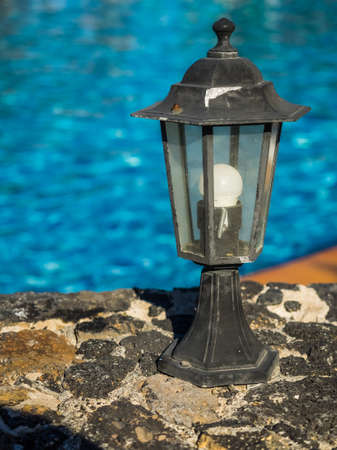Old rustic lamp standing next to the swimming poolの写真素材
