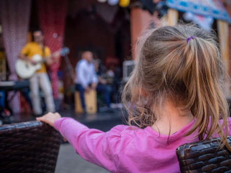 Four year old caucasian girl watching street band playing music during festival in Fuerteventura, Canary Islands, Spainのeditorial素材