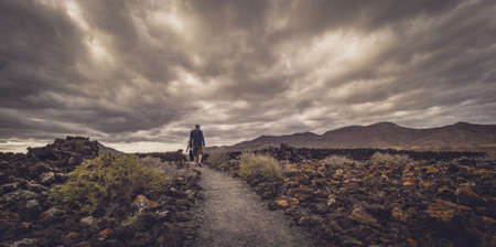 Man walking on a path leading towards the archaeological site of an old aboriginal village in Fuerteventura, Canary Islands, Spain. Picture taken 13 April 2016のeditorial素材