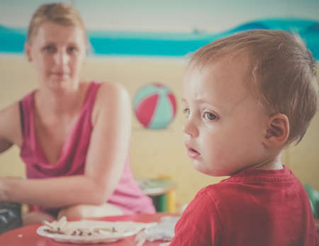 Woman looking after children drawing pictures during art time at the nurseryの写真素材