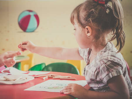 Little girl coloring a picture of a fox during art time at the nurseryの写真素材