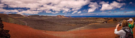 Tourists taking pictures of the Timanfaya National Park ( also called The Montanas del Fuego or Mountains of Fire ) in Lanzarote, Canary Islands, Spainのeditorial素材