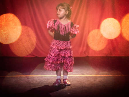 Little four years old girl dancing flamenco on stage in a theatreの写真素材
