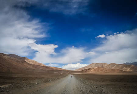 Solo female cyclist cycle touring through the stunning remote landscape of Western Tibetの写真素材