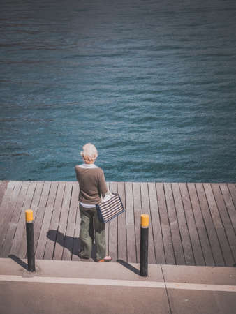 An old woman looking out at the ocean at the harbour in Playa Blanca in Lanzarote, Canary Islands, Spain. Picture taken in April 2016 in Puerto del Carmen in Lanzarote, Spainのeditorial素材