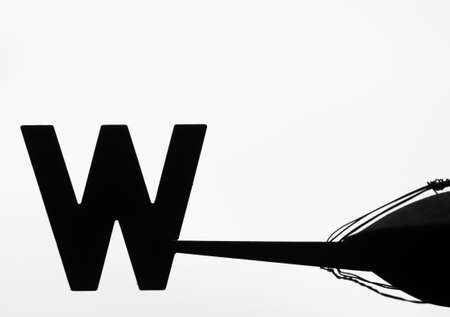 Monochrome image of an old weathervane pointing Westの写真素材