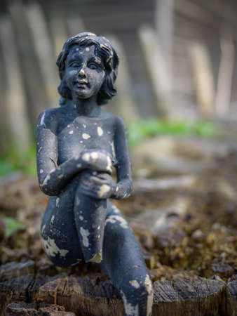 Small old damaged figurine of a female on a cut treeの写真素材