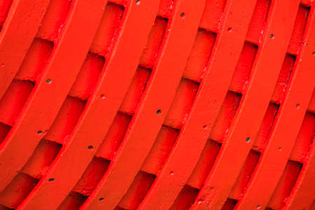 Red rows of painted wooden side of a fishermen boatの写真素材