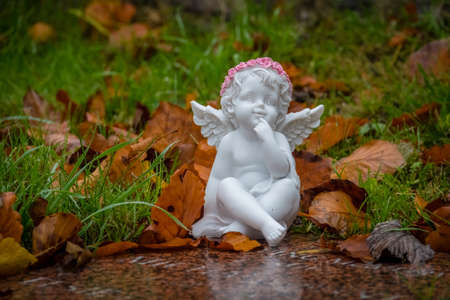 Tiny angel figure next to a child grave in cemeteryの写真素材