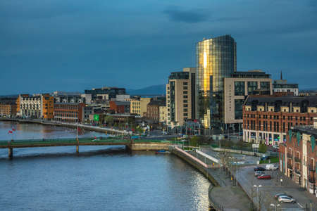 Limerick, Ireland -  April 2017 : View of the bridges over river Shannon, hotels and commercial buildings in Limerick town after sunset, Irelandのeditorial素材
