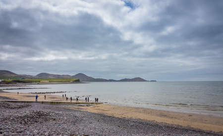 Waterville, Ireland -  April 2017 : Group of tourists walking on the Ballingskelligs Bay Beach, Waterville, County Kerry, Irelandのeditorial素材