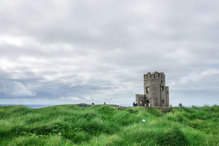 Cliffs of Moher, Ireland -  April 2017 : Tourists at the O Briens Tower at the Cliffs of Moher, Irelandのeditorial素材