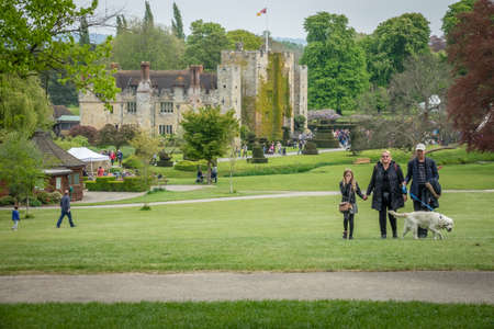 Hever Castle, England -  April 2017 : Family with a dog walking on the grass in front of the Hever Castle in Kent. It was built in the 13th century, historical home of Ann Boleyn, the second queen consort of King Henry VIII of Englandのeditorial素材