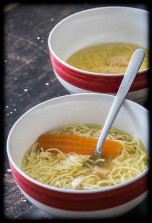 Chicken broth soup in a bowl on a tableの写真素材