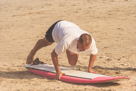 Man learning to surf on the Kuta beach in Bali in Indonesiaの写真素材