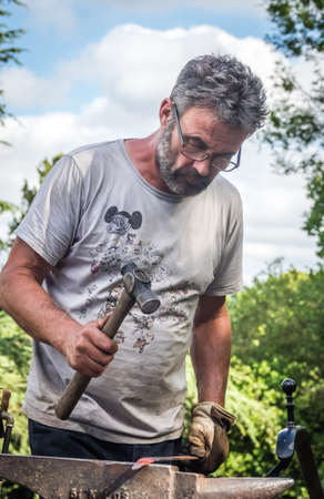 London, England -  June 2017 : A blacksmith hammering hot iron during medieval fair festival in Streatham Parkのeditorial素材