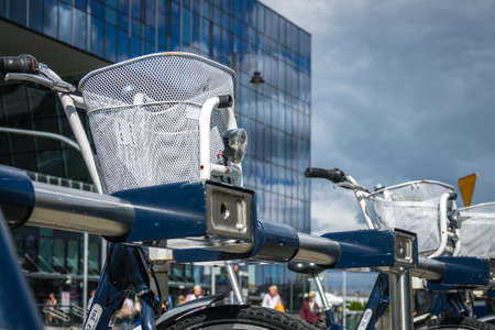Bydgoszcz, Poland -  August 2017 : Public bicycles with white baskets attached to railing in front of the newly refurbrished Bydgoszcz Glowna train station buildingのeditorial素材