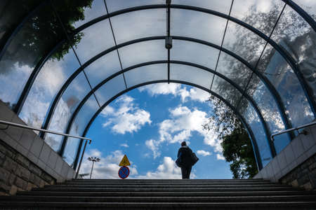 Bydgoszcz, Poland -  August 2017 : Woman on top of the stairs leaving the exit of the underground tunnel or underpass under busy roundaboutのeditorial素材