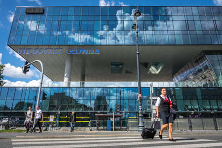 Bydgoszcz, Poland -  August 2017 : Woman traveler crossing the road in front of the newly refurbrished Bydgoszcz Glowna train station buildingのeditorial素材